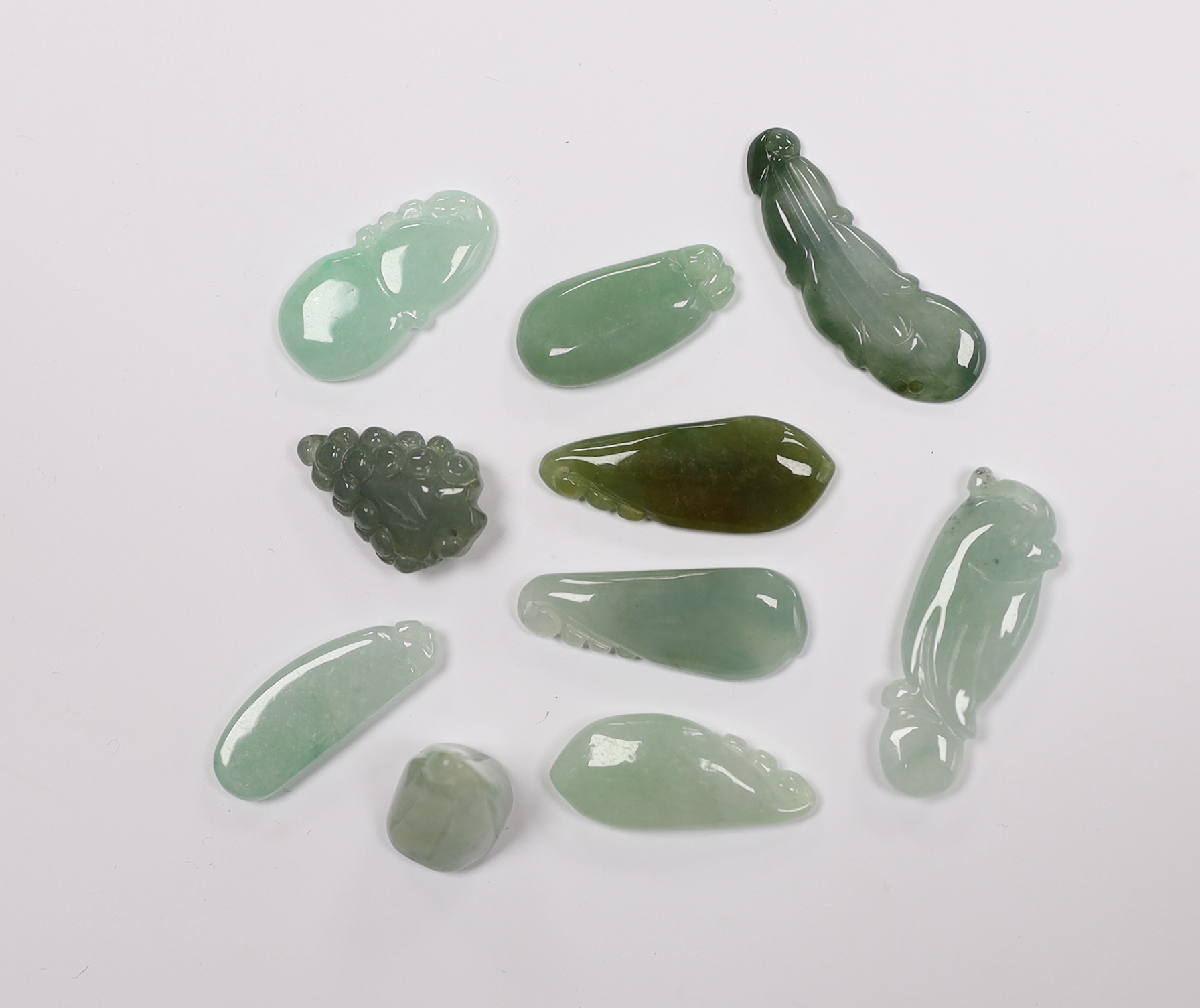 Ten various Chinese carved jadeite pendants